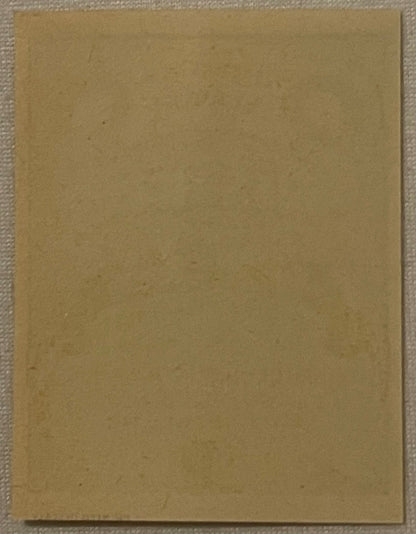 Blank tan cardboard label on textured fabric surface, photographed flat