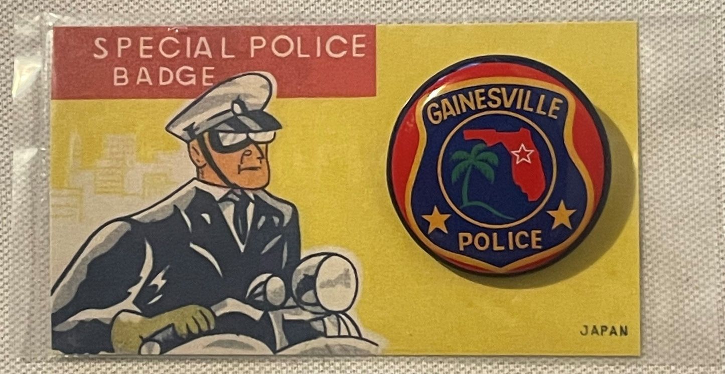 Vintage tin lithography police badge on original packaging showing Gainesville Police emblem with palm tree and stars, displa
