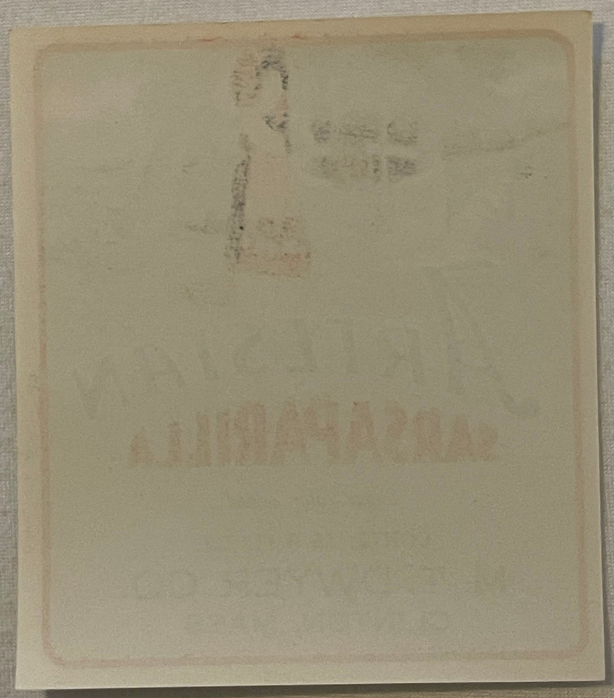 Reverse of the Artesian Sarsaparilla label, close up: plain paper with the front artwork and lettering showing faintly through from the other side.