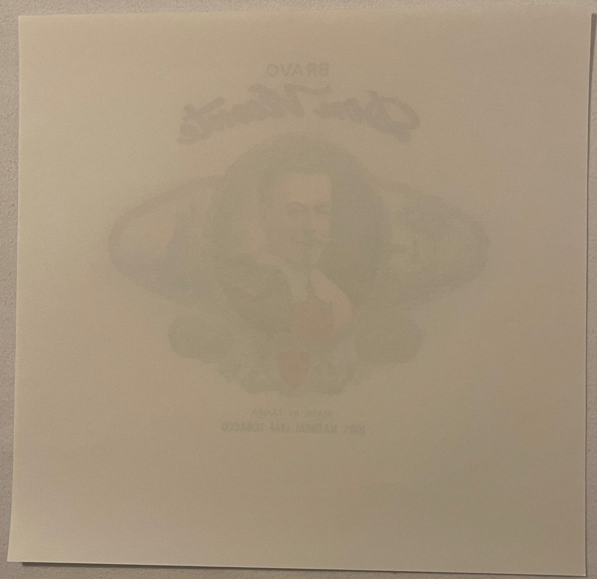 Faded embossed cigar box label showing a man's portrait, tan paper background, barely legible text at top and bottom