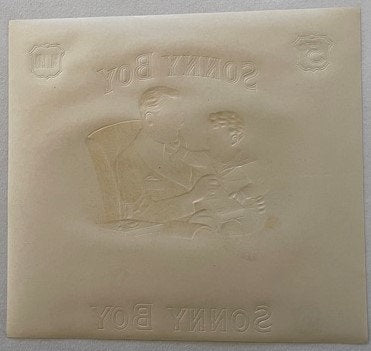 Cream-colored embossed cigar label with "Sonny Boy" text and classical figures in relief, shown flat at angle