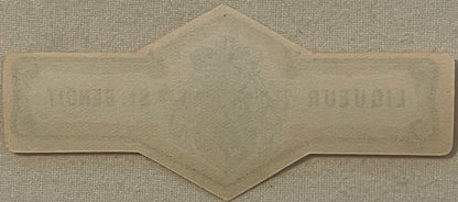 Blank cream-colored vintage bottle neck label with decorative scalloped edges and pointed top, photographed flat on textured 