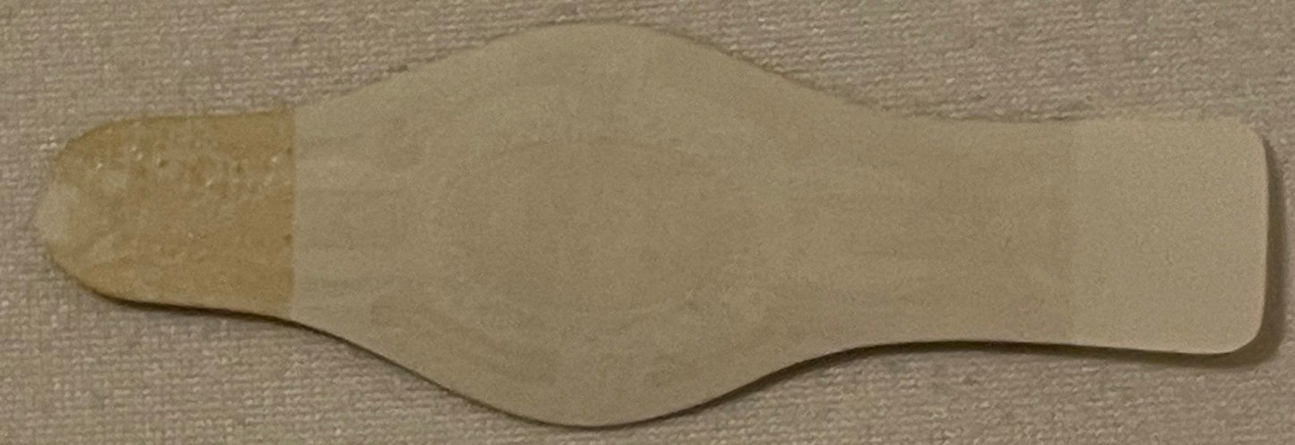 Cream-colored embossed cigar band with curved edges on textured beige fabric background