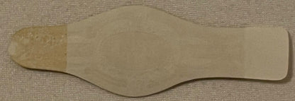 Cream-colored embossed cigar band with curved edges on textured beige fabric background