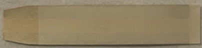 Vintage cigar band label with gold and brown coloring on aged cream paper, photographed flat against neutral background