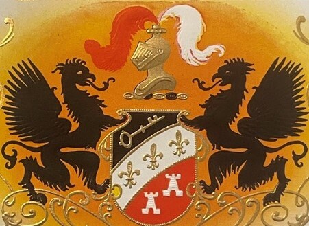 Gold embossed cigar label featuring two black dragons flanking a heraldic shield with fleur-de-lis and castle designs on oran