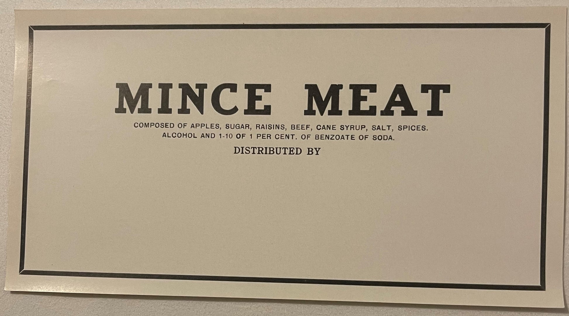 Antique mince meat label with black border on cream background, listing ingredients including apples, sugar, raisins, beef