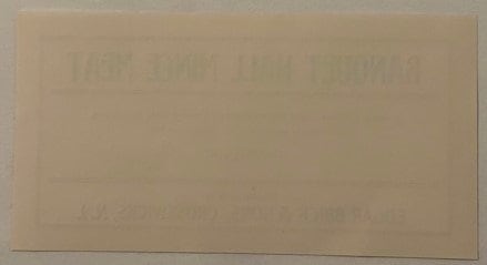 Faded antique mince meat label with embossed text, tan paper with minimal visible printing, photographed flat against neutral