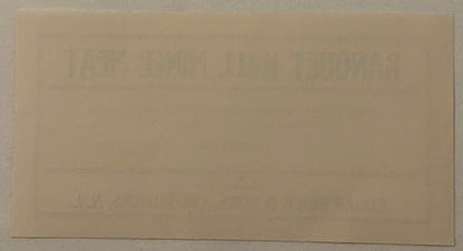 Faded antique mince meat label with embossed text, tan paper with minimal visible printing, photographed flat against neutral