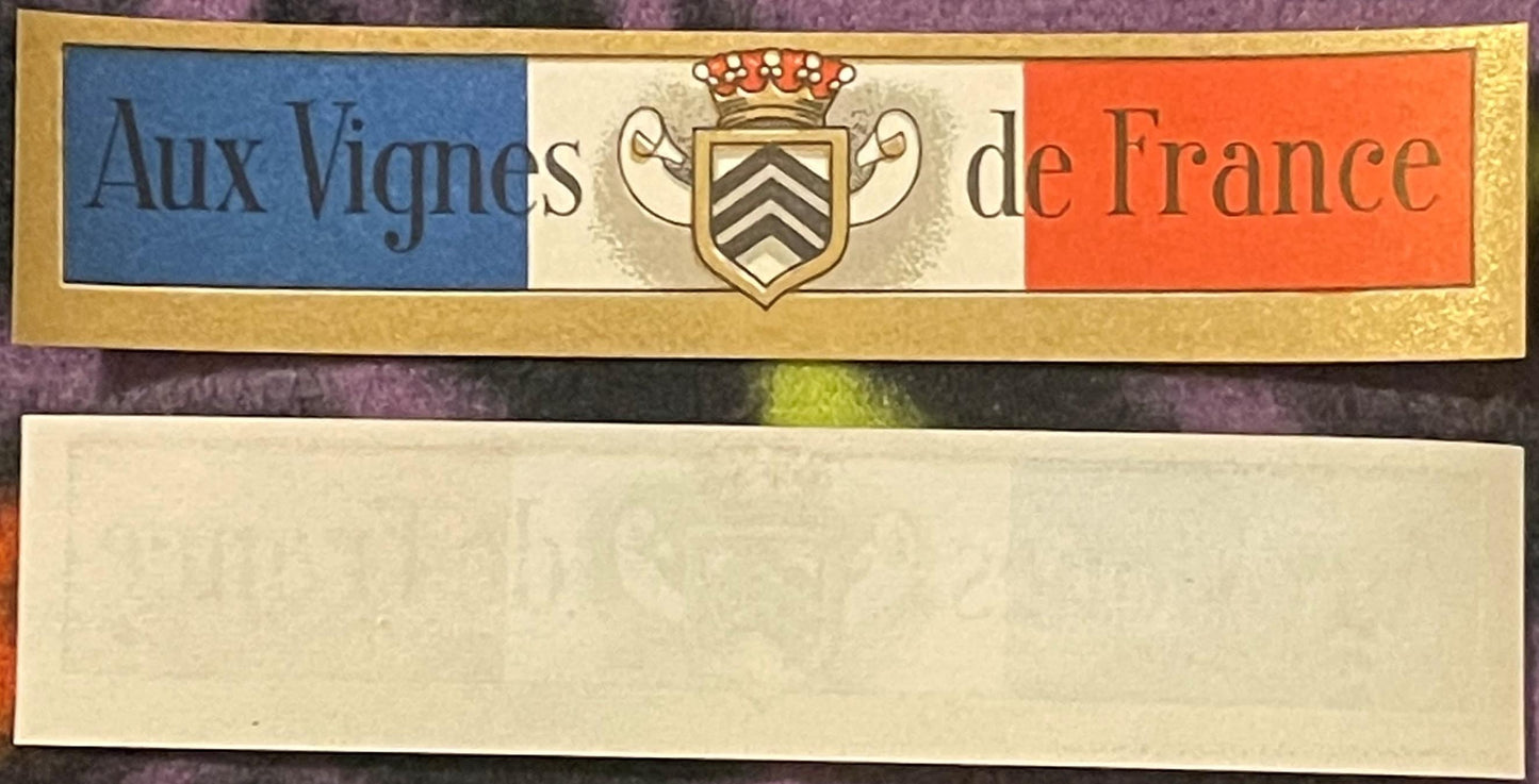 Vintage French wine label with blue, white, and red tricolor stripes, ornate coat of arms, and "Aux Vignes de France" text on