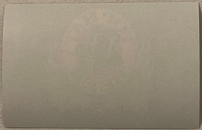 The reverse of the label: plain unprinted paper, with the front's ink faintly showing through the sheet.