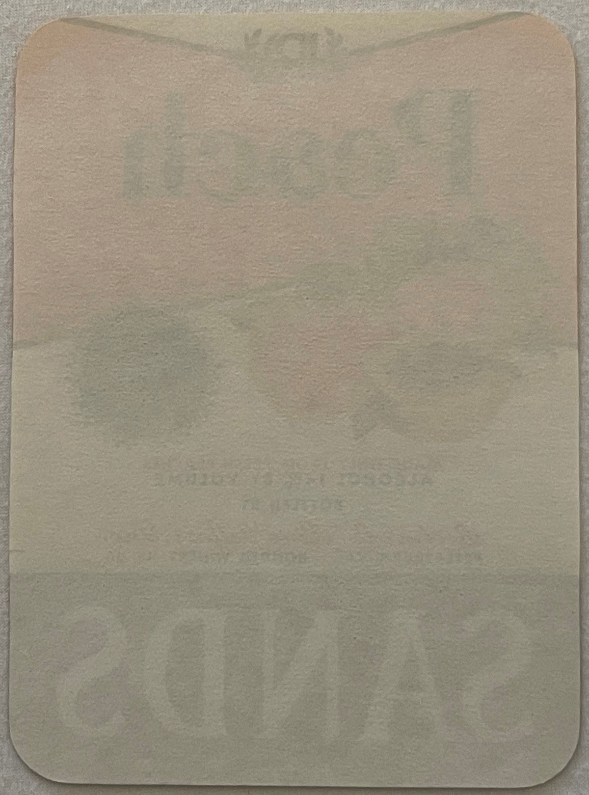 The reverse of the label: plain unprinted paper, rounded corners. What shows through faintly is the front's own ink coming through the sheet, not printing on the back.