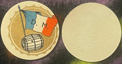 Two circular cream-colored wine barrel labels showing front and back sides; front features gold textured background, blue and