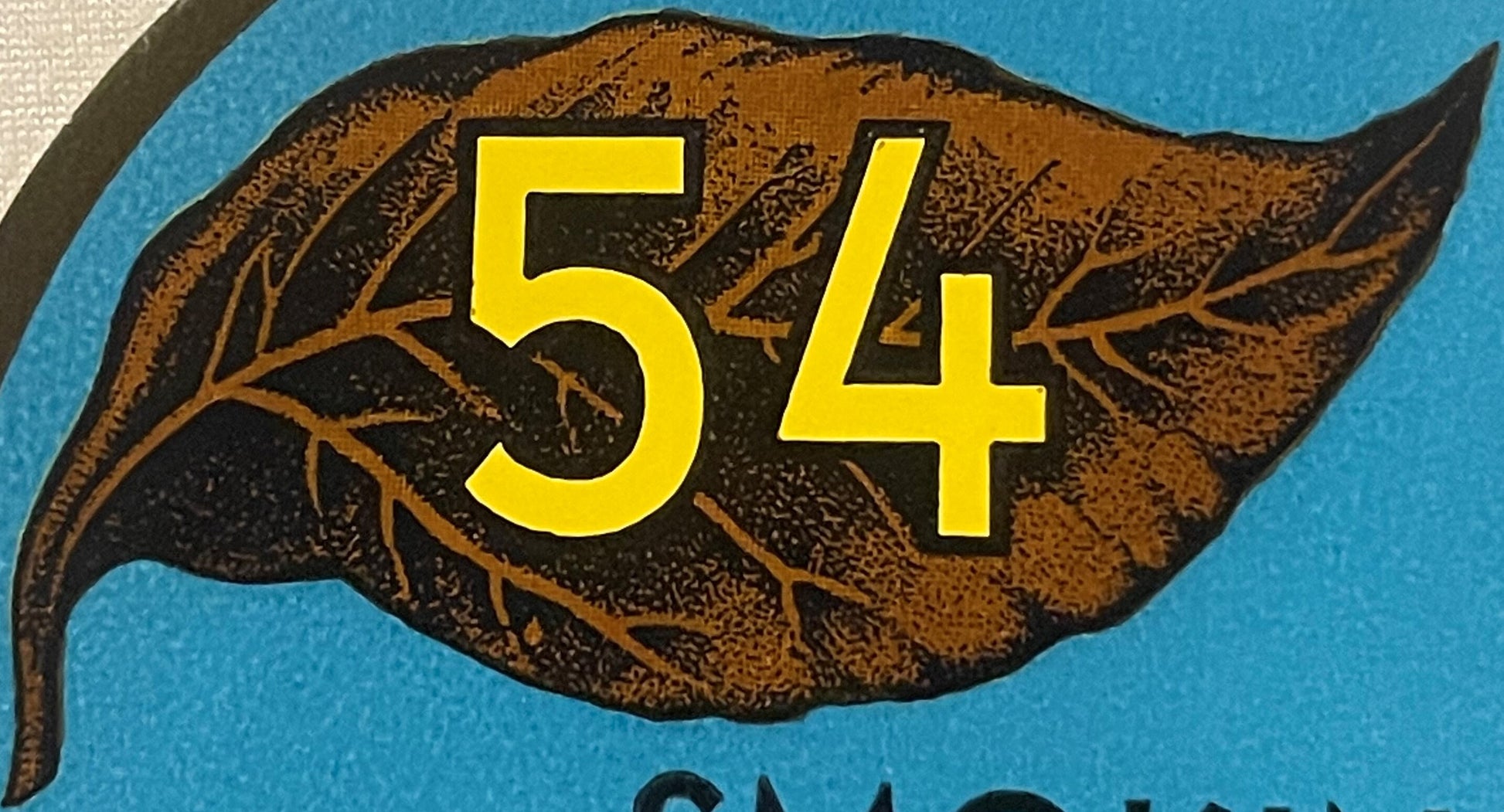 Vintage tobacco label featuring large yellow "54" numerals overlaid on a brown leaf illustration against blue background