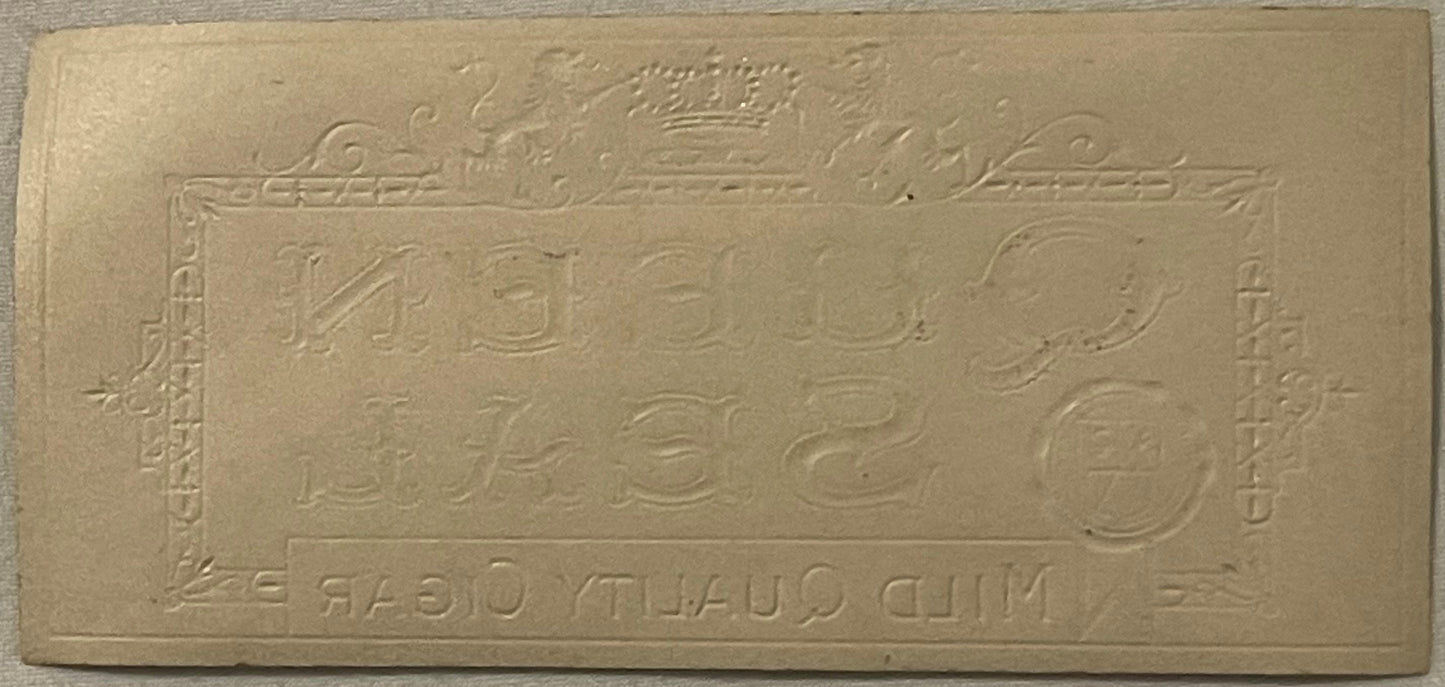 Cream-colored embossed cigar box label with gold crown at top and ornamental borders, featuring numbers and reversed text at 