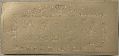 Cream-colored embossed cigar box label with gold crown at top and ornamental borders, featuring numbers and reversed text at 