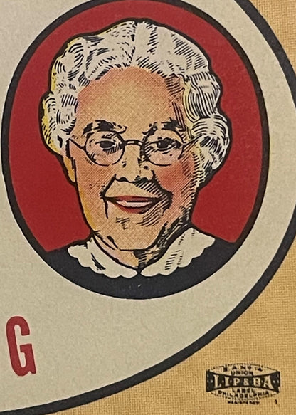 Vintage soda bottle label featuring portrait of elderly woman with white hair and glasses on red background, letter G and "Me