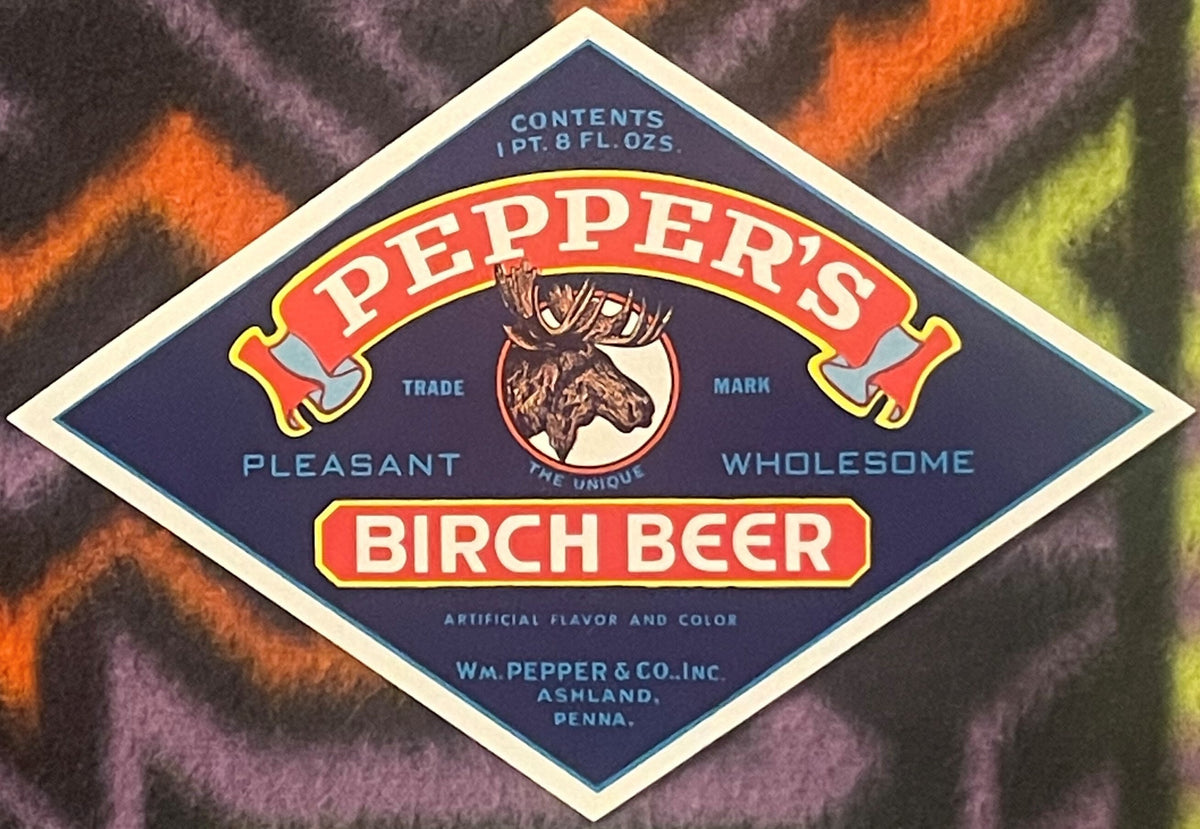 Vintage navy blue diamond-shaped Pepper's Birch Beer bottle label with red banner, moose head emblem, and cream border