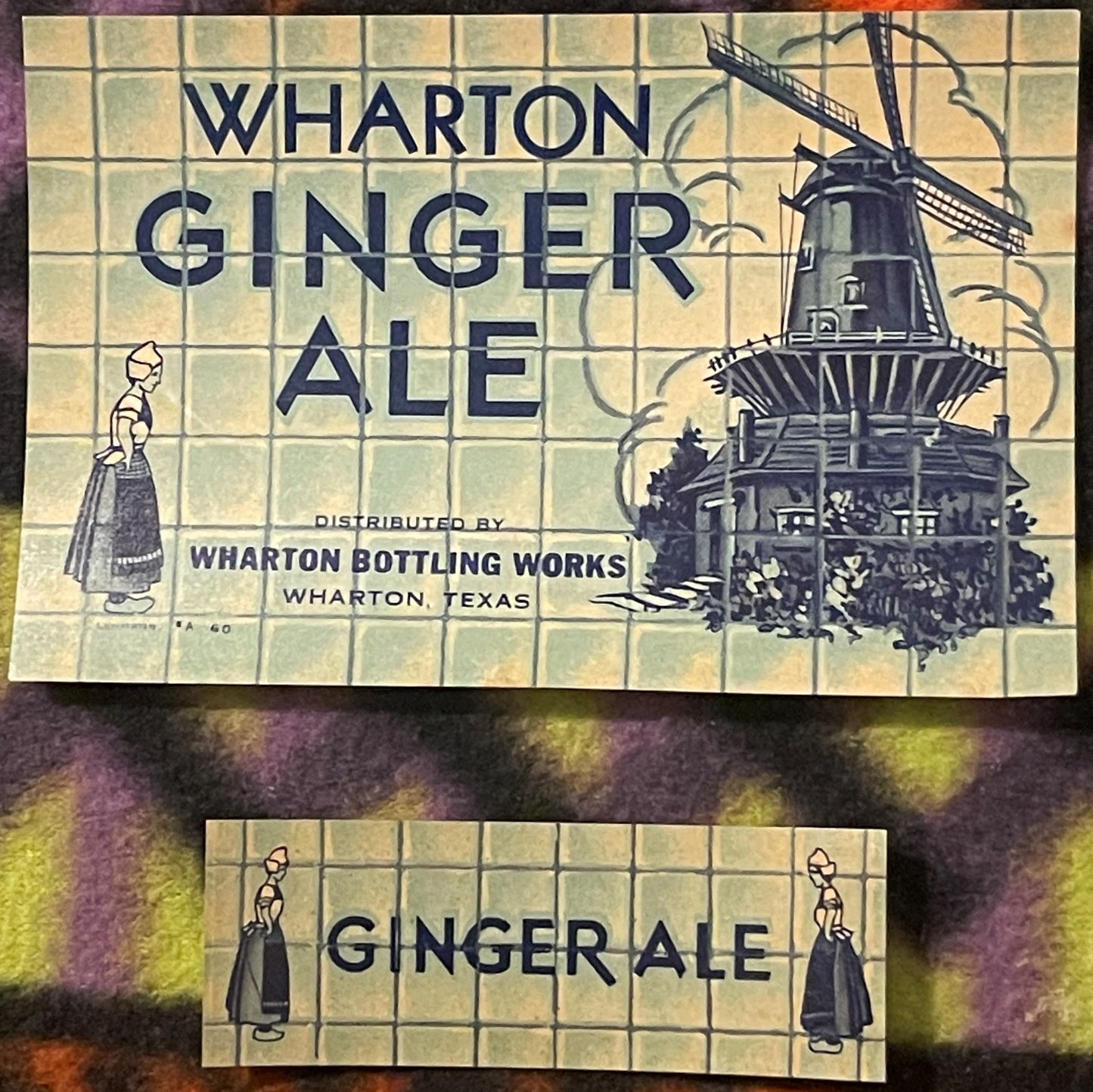 Two vintage Wharton Ginger Ale labels from Texas featuring Dutch girl illustrations and a windmill, cream-colored with blue t