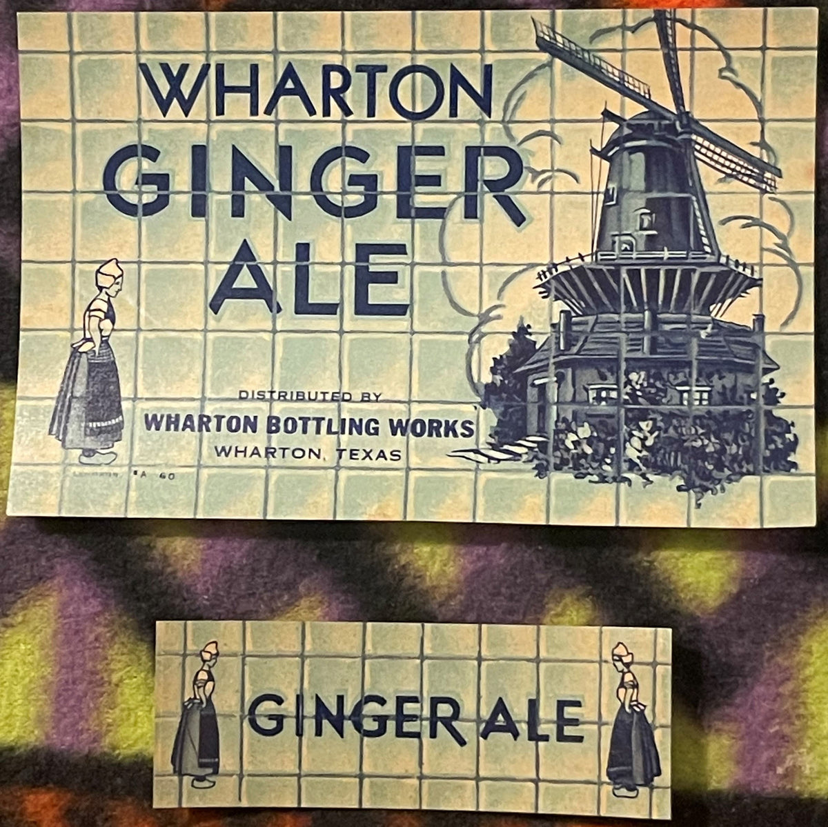 Two vintage Wharton Ginger Ale labels from Texas featuring Dutch girl illustrations and a windmill, cream-colored with blue t
