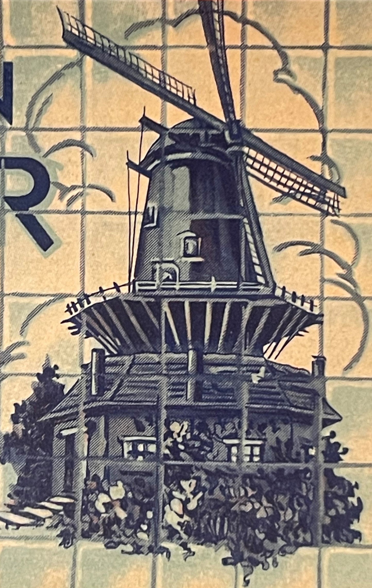 Vintage ginger ale label featuring a Dutch windmill with turning blades, base building, and foliage on cream and blue tiled b