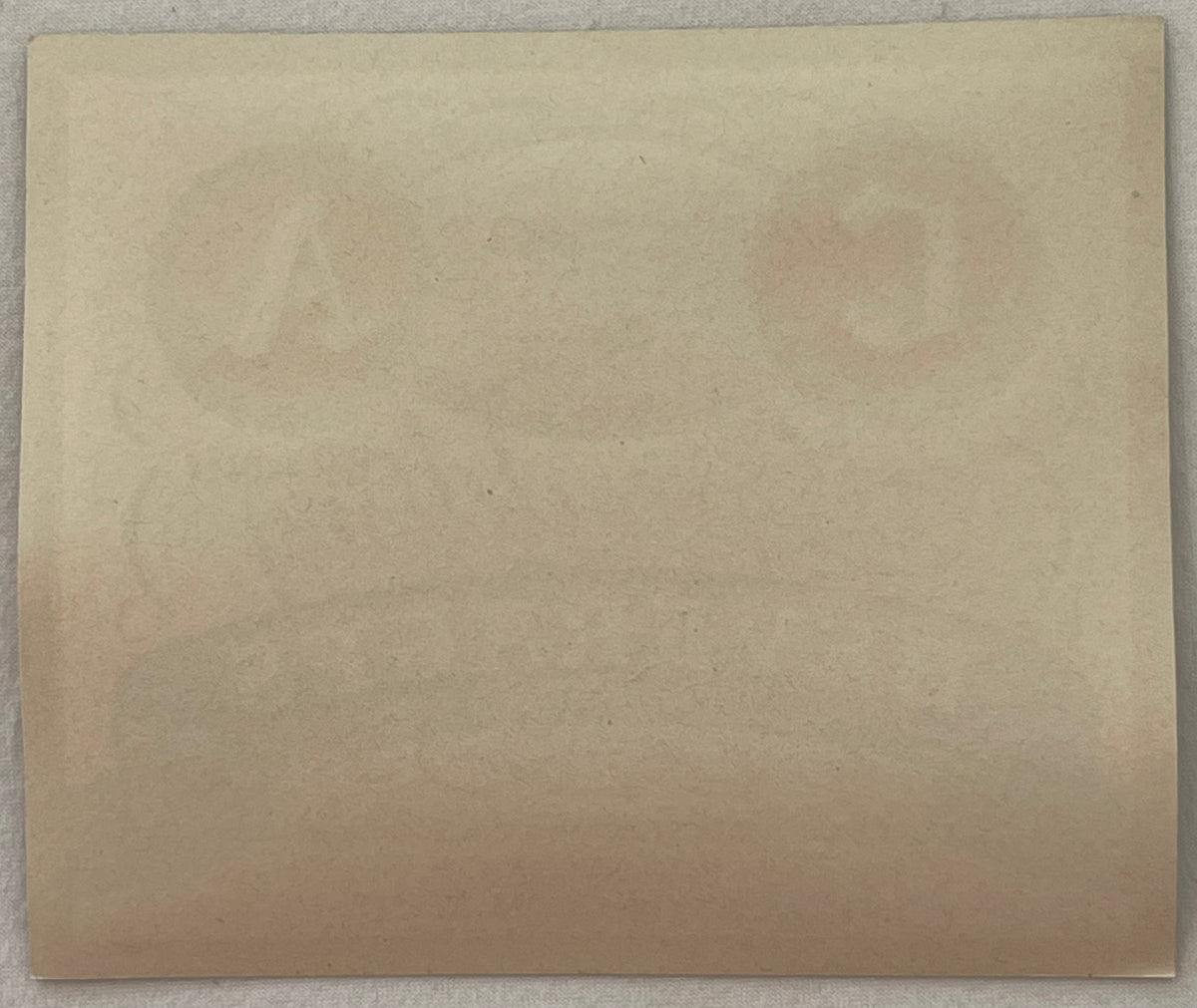 Blank cream-colored vintage label or paper, photographed flat against gray