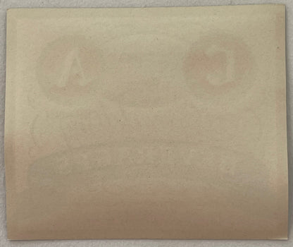 Blank cream-colored vintage label or paper, photographed flat against gray