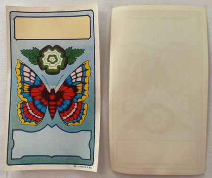 Vintage butterfly broom label showing colorful lithographed butterfly with red wings and decorative flower, displayed front a