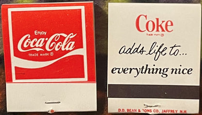 Two vintage Coca-Cola matchbooks displayed side by side: left shows classic red "Enjoy Coca-Cola" design; right displays "Cok
