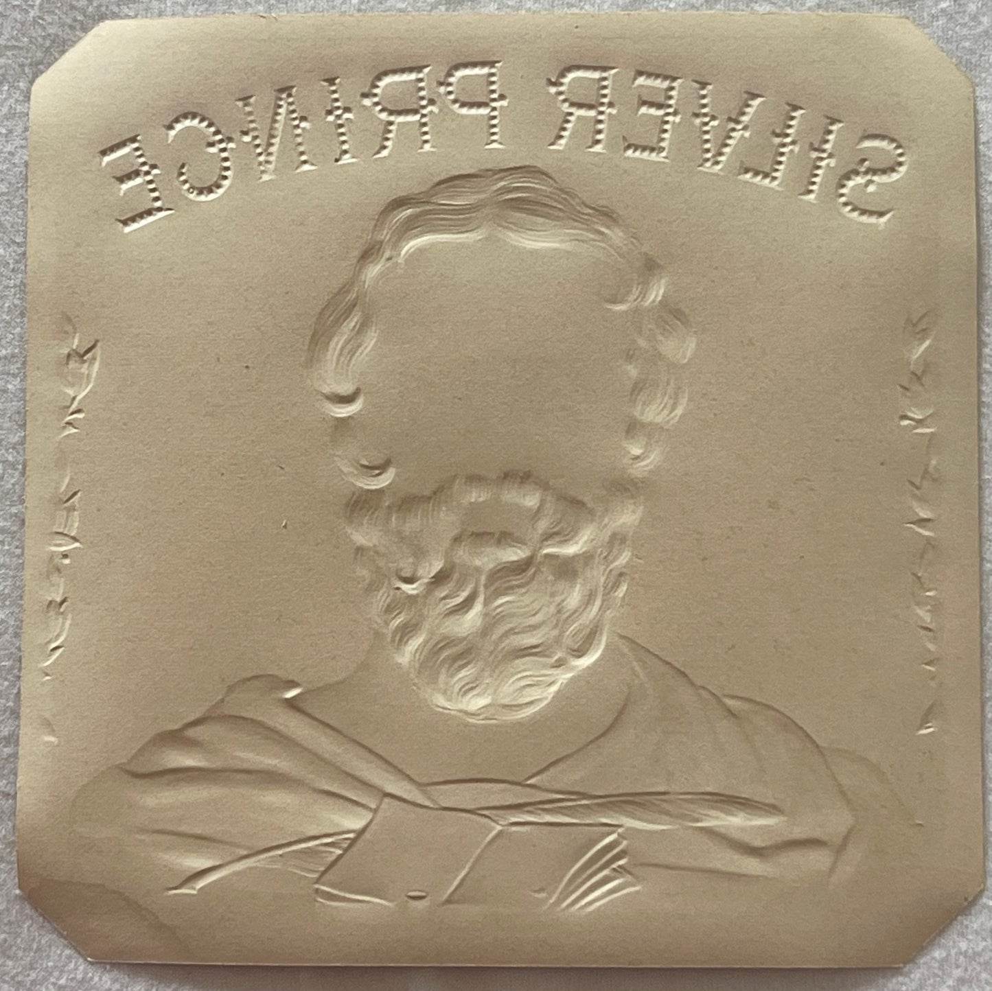 Cream-colored embossed metal plaque with bearded man's portrait and text reading "DUFFYSHIP" at top, shown against gray surfa