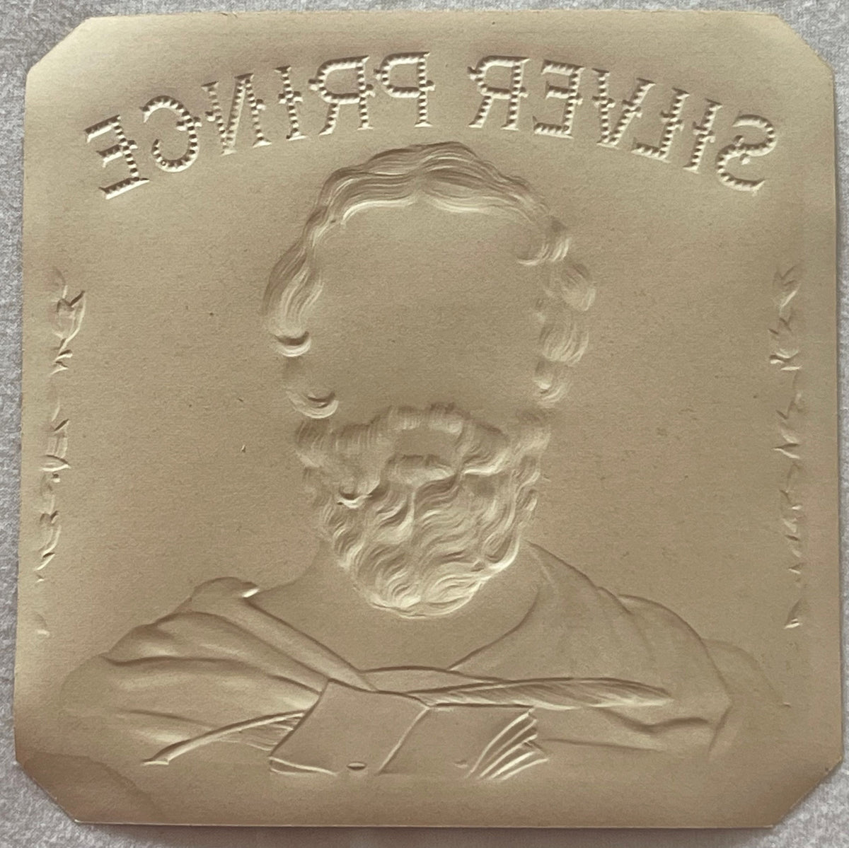 Cream-colored embossed metal plaque with bearded man's portrait and text reading "DUFFYSHIP" at top, shown against gray surfa