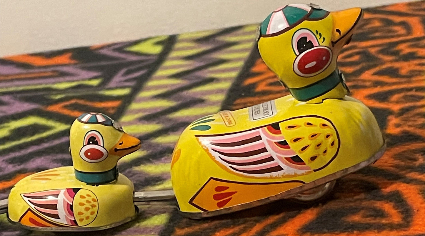 Close view of the tin litho mother duck with one duckling, showing the painted goggles, red cheeks and orange bill.