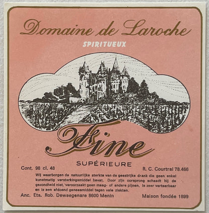 Vintage pink label for Domaine de Laroche spiritueux with engraved castle illustration surrounded by vineyard landscape