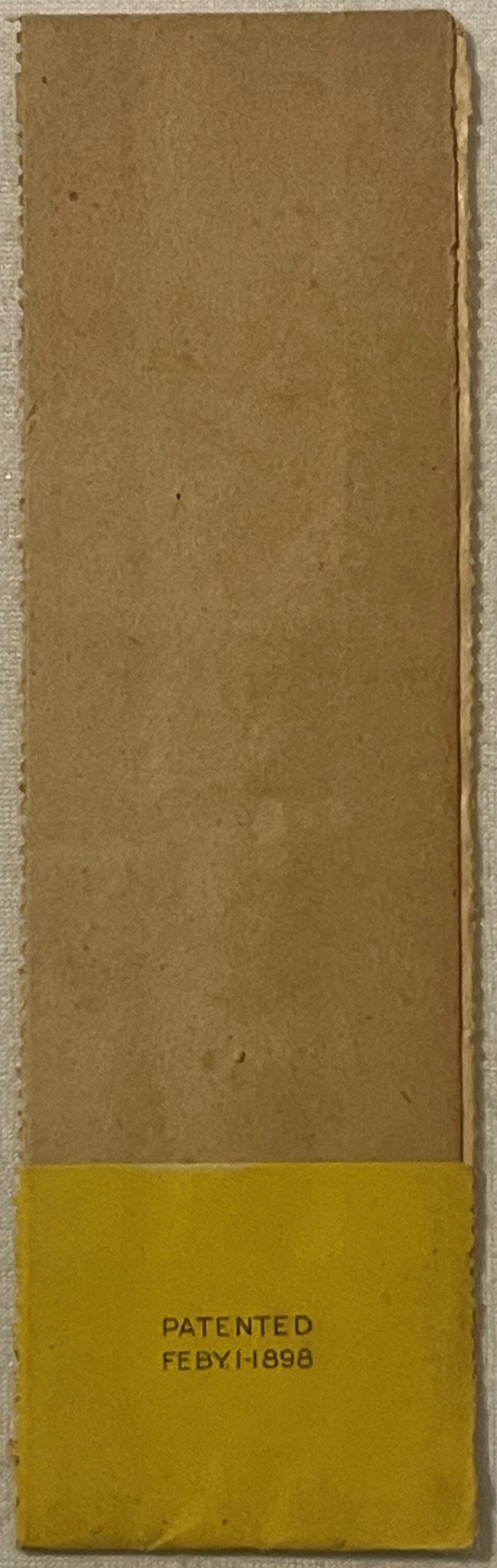 Tan kraft paper label with yellow bottom section printed "PATENTED FEBY.1-1898", displayed flat against light background