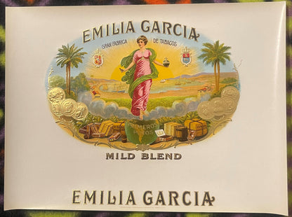 Antique Emilia Garcia cigar box label with embossed gold design featuring a woman in pink robes, palm trees, coins, and "Mild