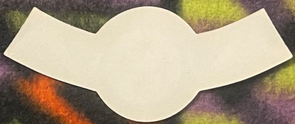 Blank cream-colored wine neck label with scalloped edges displayed against a textured background with purple, green, and oran