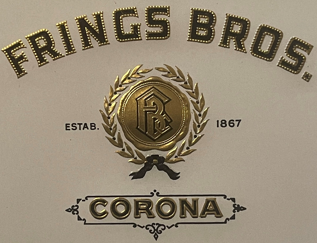 Gold embossed cigar label for Frings Bros Corona brand, established 1867, featuring ornate wreath and monogram seal on cream background.