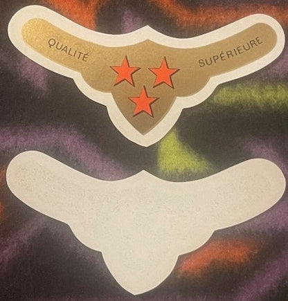 Vintage wine label with tan and cream winged design, three red stars, and "QUALITÉ SUPÉRIEURE" text on colorful marbled backg