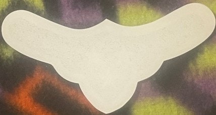 Cream-colored wine label with scalloped edges against colorful abstract background in orange, yellow, and purple tones
