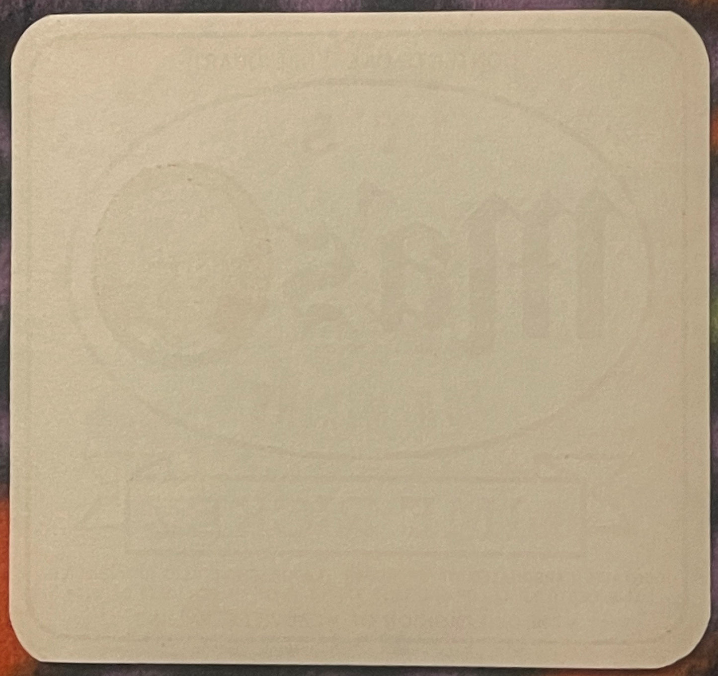 Blank cream-colored vintage soda bottle label with rounded corners on dark wooden surface