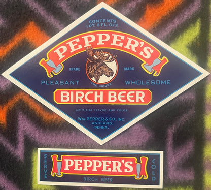 Two vintage Pepper's Birch Beer labels with moose head trademark on navy blue background with red and yellow banners, display
