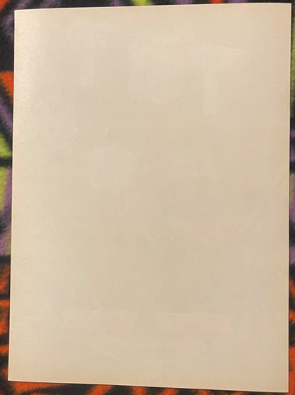 Blank cream-colored vintage crate label on colorful patterned background for scale