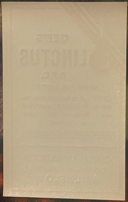 Faded cream-colored vintage medicine label with embossed text, photographed straight-on against dark background