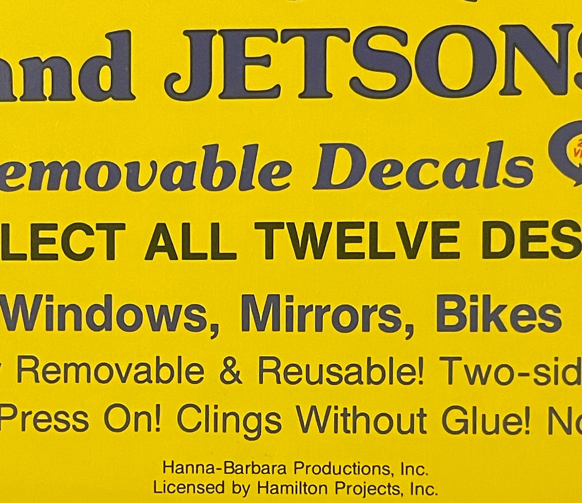 Yellow vending display sign with dark gray text advertising Hanna-Barbera Flintstones and Jetsons removable decals, showing p