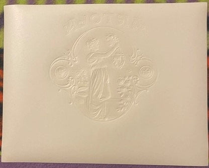 Cream-colored embossed cigar label featuring a classical Roman woman figure surrounded by decorative scrollwork
