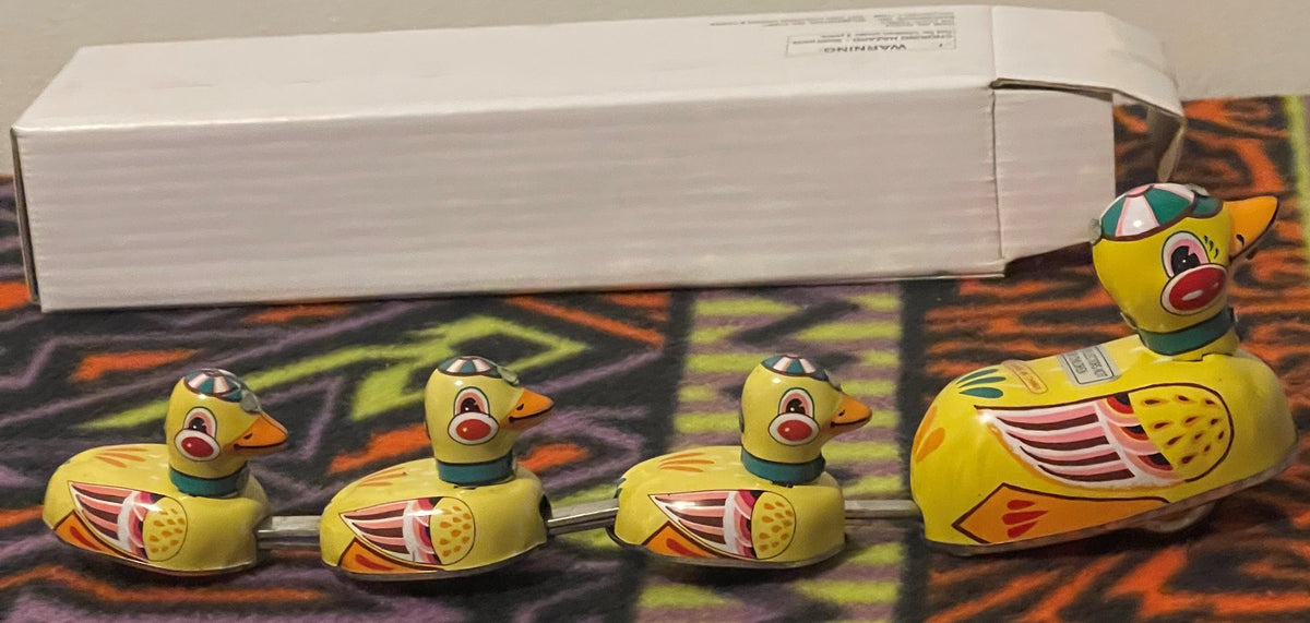 The four linked tin ducks in a row with the plain white Bandwagon box lying behind them.