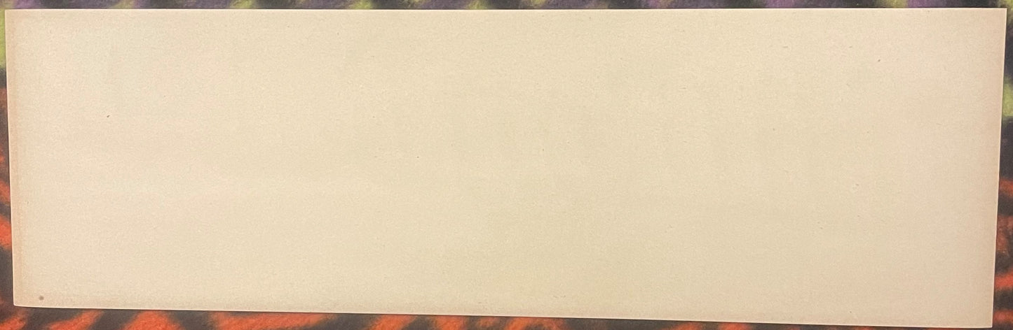 Blank cream-colored vintage fruit crate label on patterned surface, front view showing empty label space