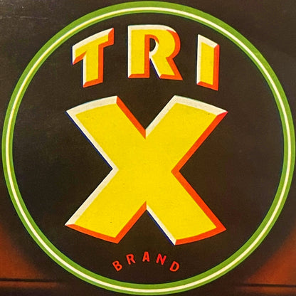 Vintage circular crate label with yellow "TRI" text and large X symbol, green border, dark background, "BRAND" text at bottom