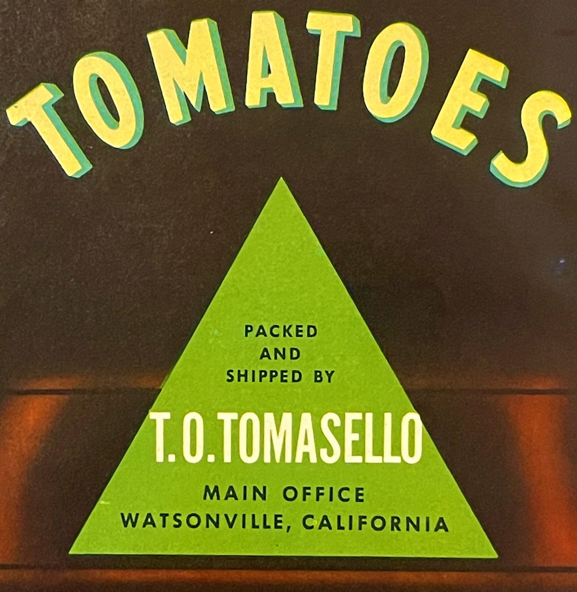 Vintage tomato crate label with yellow "TOMATOES" text and green triangle containing "T.O. TOMASELLO" and "WATSONVILLE, CALIF
