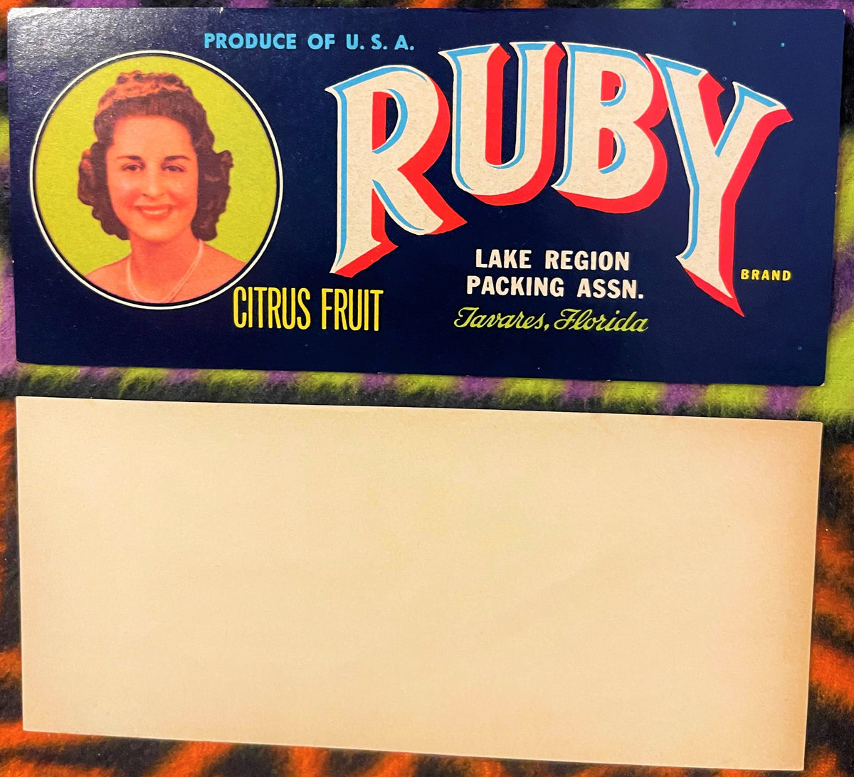 Vintage Ruby Brand citrus fruit crate label featuring a portrait of a woman in yellow circle, red and blue lettering, Lake Re